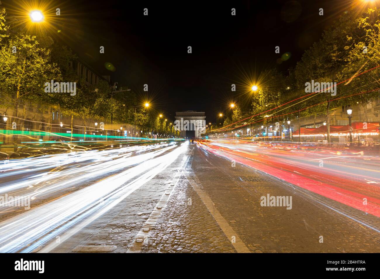 Avenue des Champs Elysee mit Lichtspuren fahrender Autos und dem Triumpfbogen, Paris, Frankreich, Europa Stock Photo