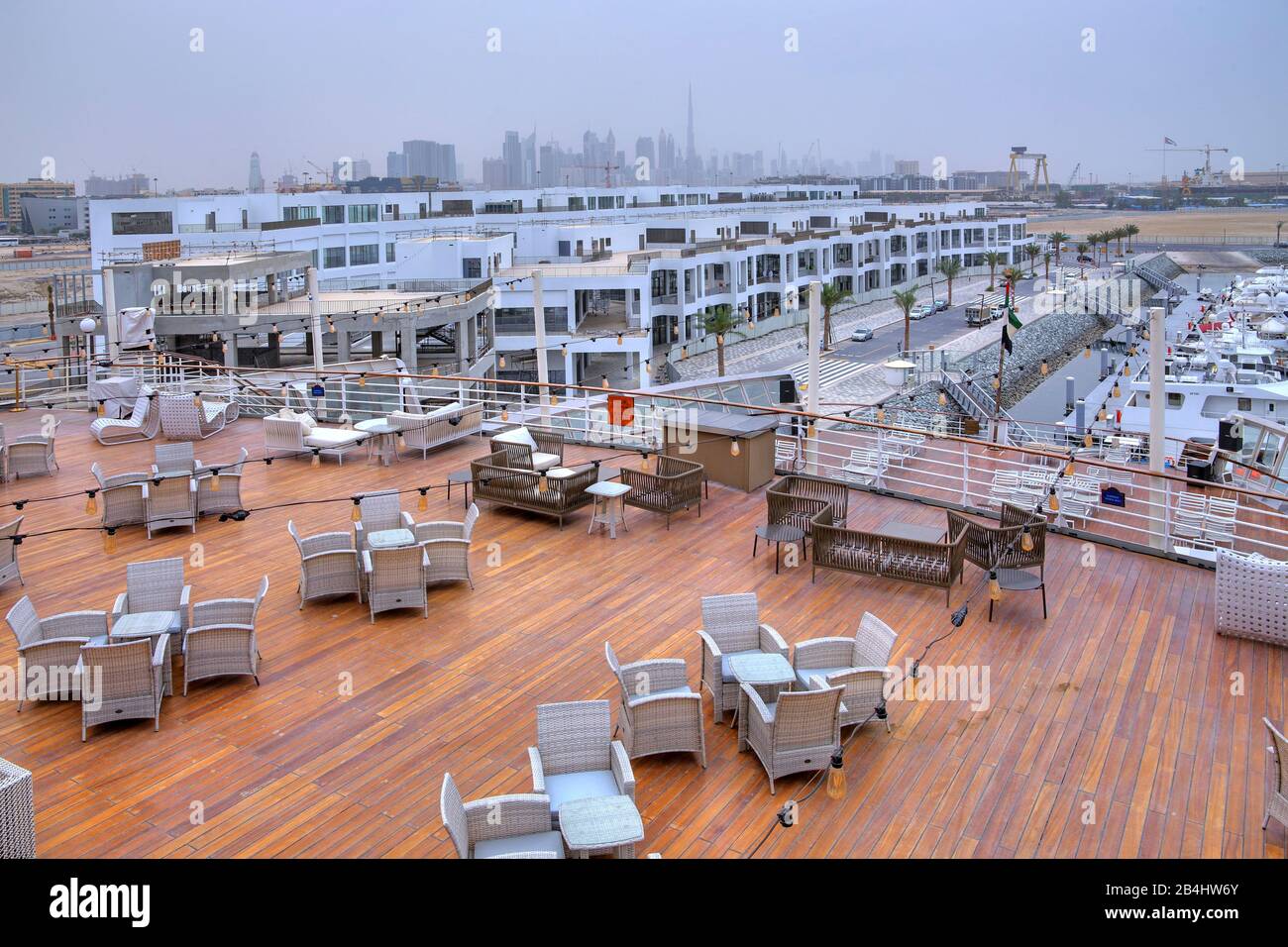 Exterior deck on the hotel and museum ship Queen Elizabeth 2 (QE2) with apartment buildings and city skyline, Dubai, Persian Gulf, United Arab Emirates Stock Photo