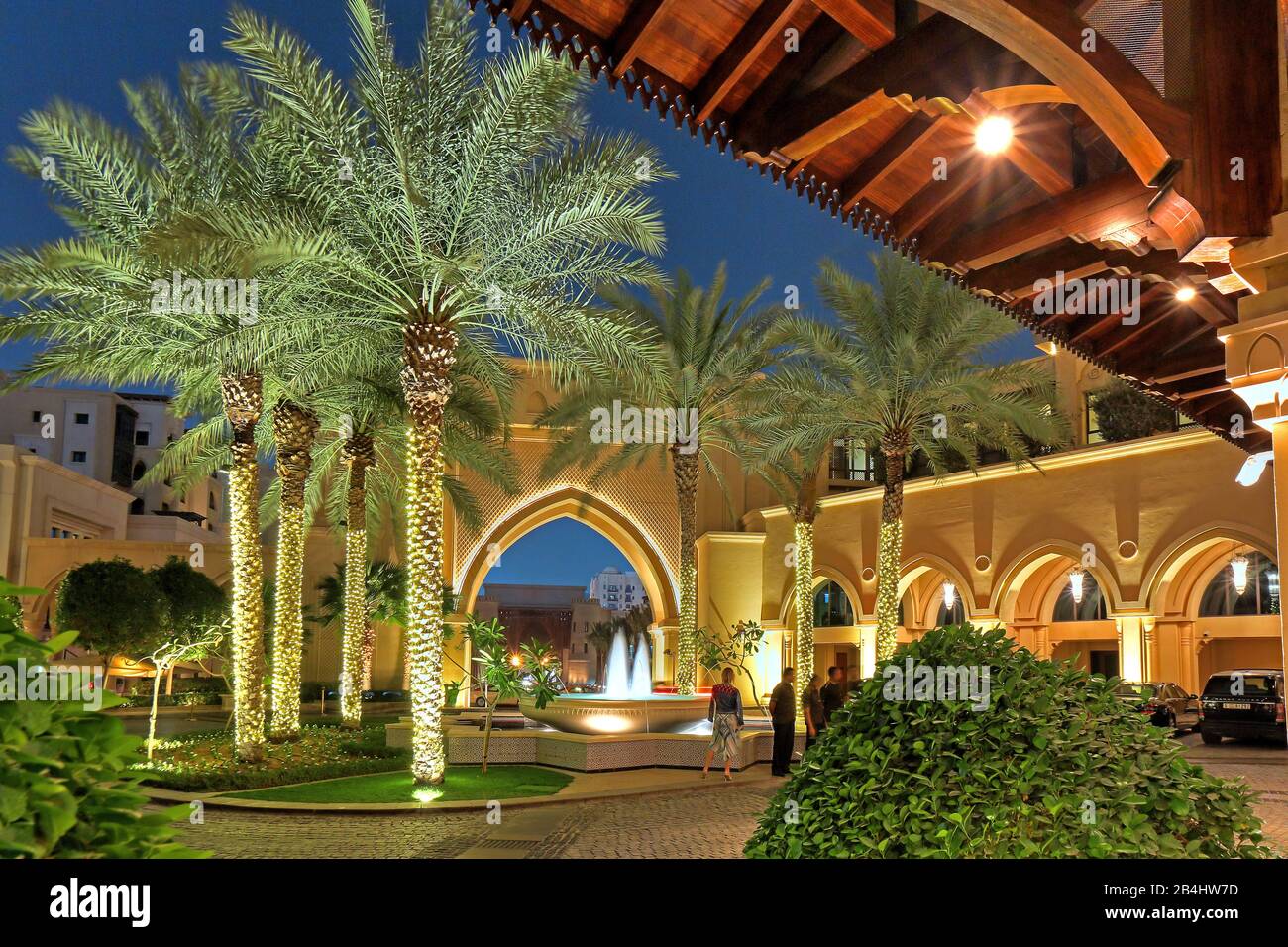 Forecourt to the hotel The Palace Downtown with palm trees and fountains at night in Downtown, Dubai, Persian Gulf, United Arab Emirates Stock Photo
