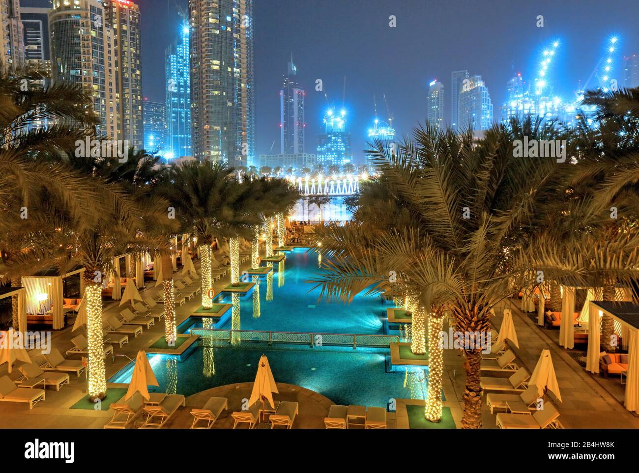 Garden with swimming pool at The Palace Downtown hotel at night in Downtown, Dubai, Persian Gulf, United Arab Emirates Stock Photo