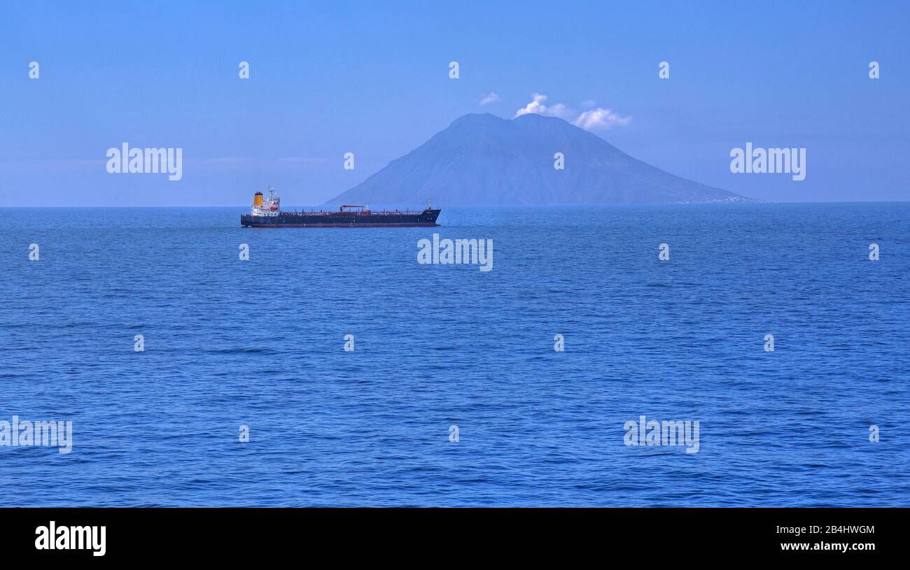 Cargo ship in front of the volcanic island Stromboli 926m, Aeolian Islands, Lipari Island, Tyrrhenian Sea, Mediterranean Sea, Italy Stock Photo