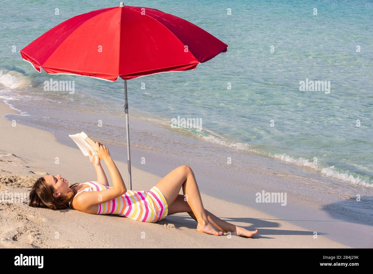 read, teenagers, umbrella, beach, lie Stock Photo