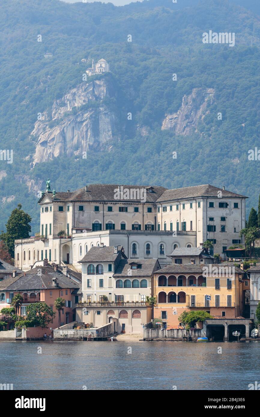 Europa, Italien, Piemont, Orta San Giulio. Blick auf die Isola San Giulio mit der Abtei Mater Ecclesiae. Oberhalb der Felsen liegt im Hintergrund das Stock Photo