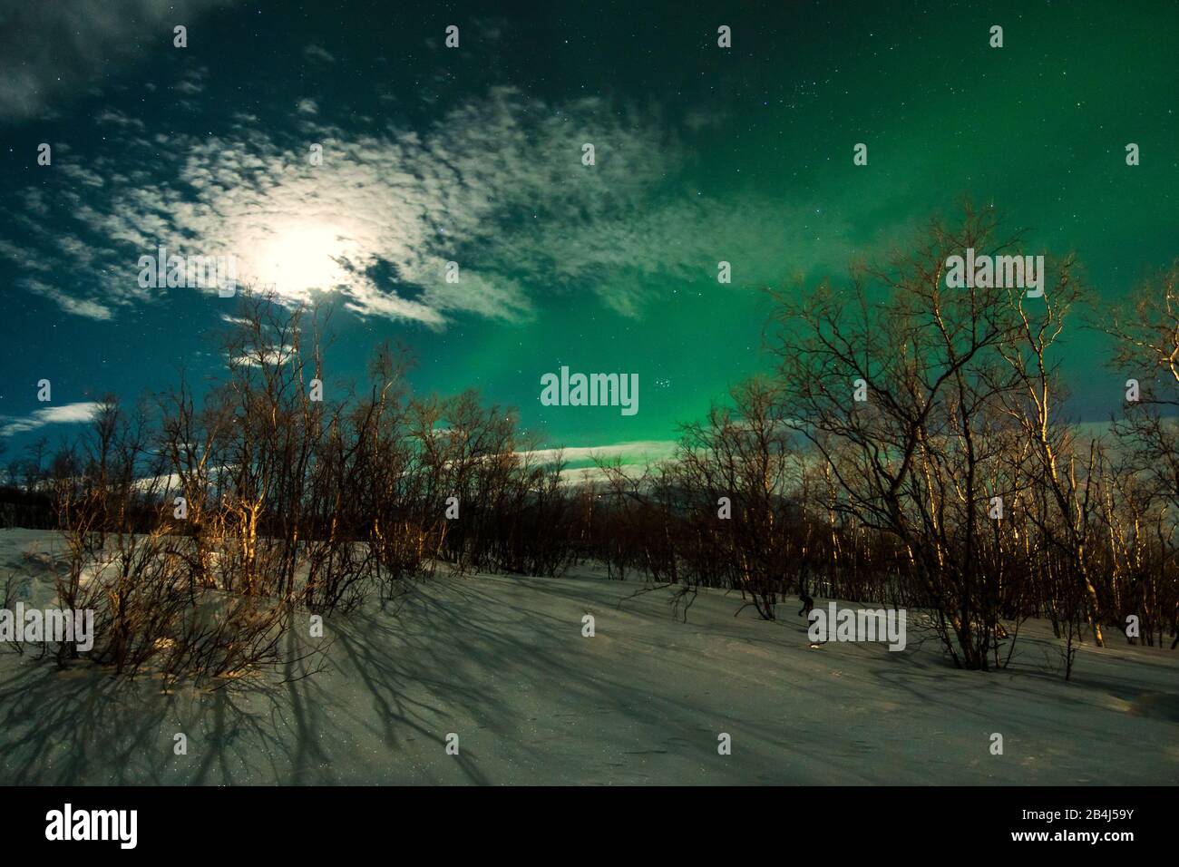 Lappland, schneebedeckte Berglandschaft, Polarlicht und Mondschein mit Wolken Stock Photo