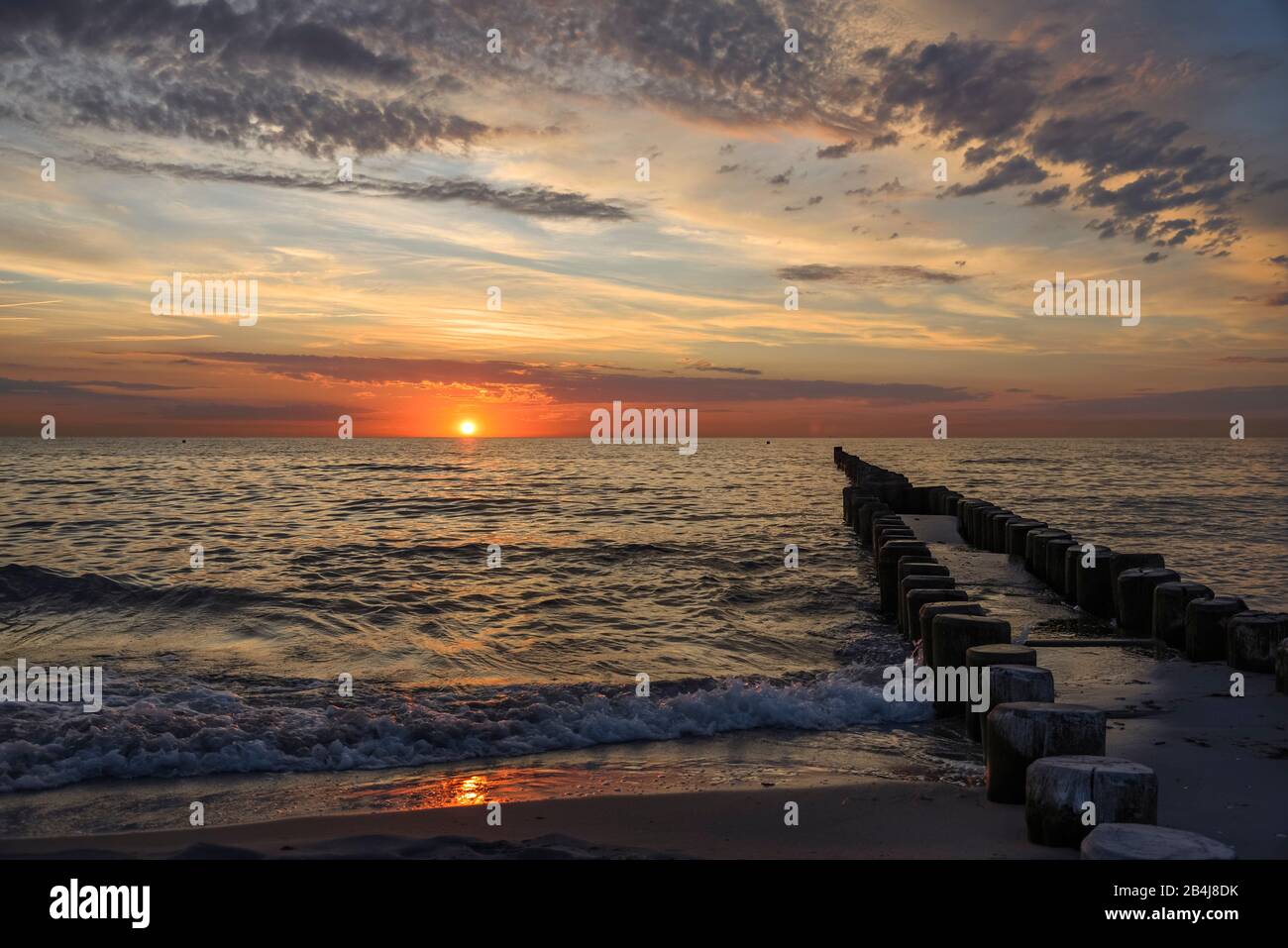 View over the Baltic Sea with breakwater with setting sun in summer Stock Photo