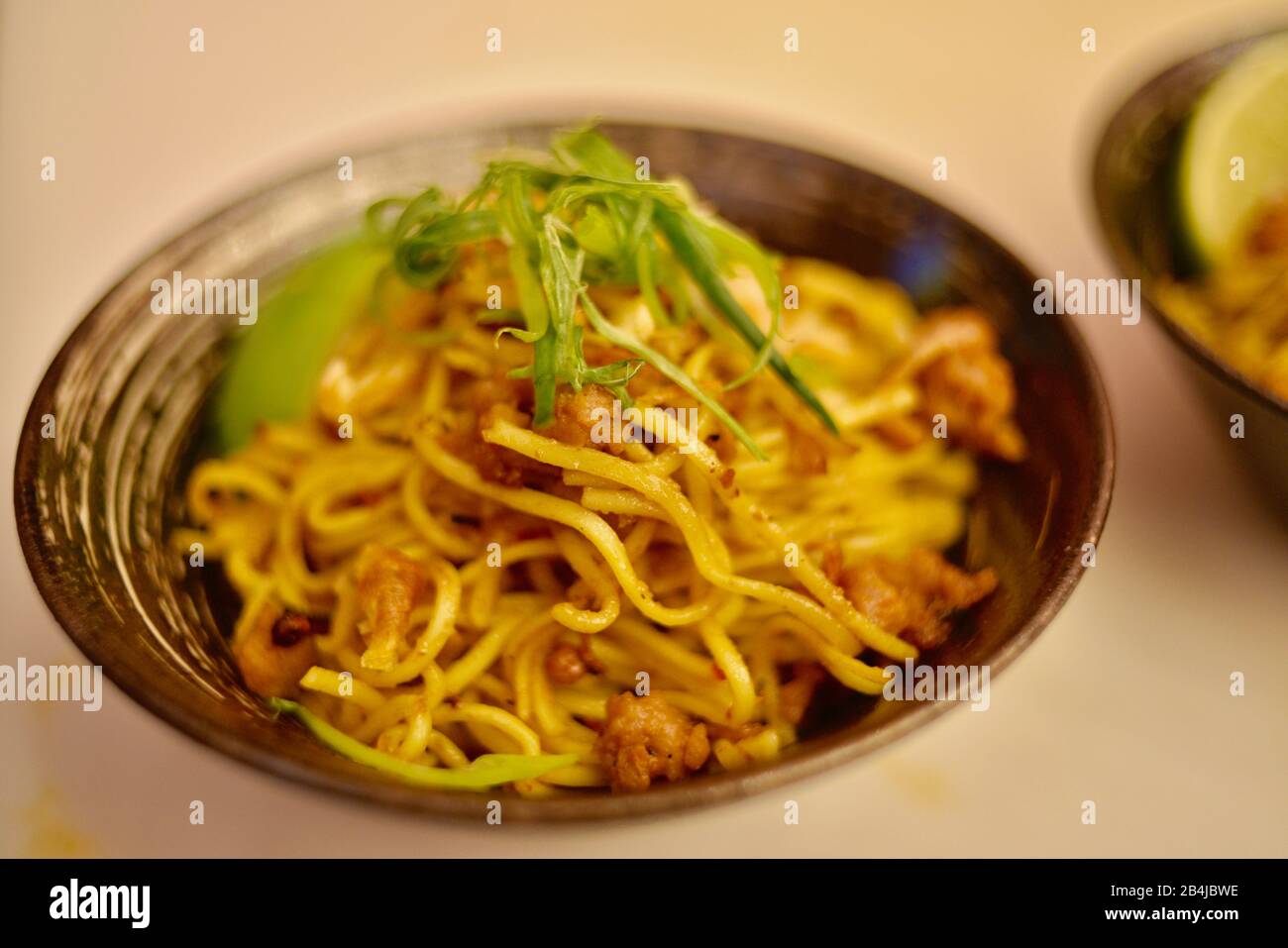 Vegan, plant-based protein (fake meat) 'pork' in Chinese Dan Dan noodles made with Impossible Pork sampled by attendees at CES, Las Vegas, NV, USA Stock Photo