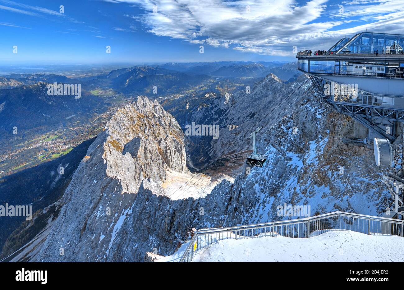 Cable car gondola and summit station of the Bavarian Zugspitze Railway on the summit of Zugspitze (2962m) with views of Waxenstein (2277m), Höllental and Garmisch Valley, Grainau, Wetterstein Mountains, Werdenfelser Land, Upper Bavaria, Bavaria, Germany Stock Photo