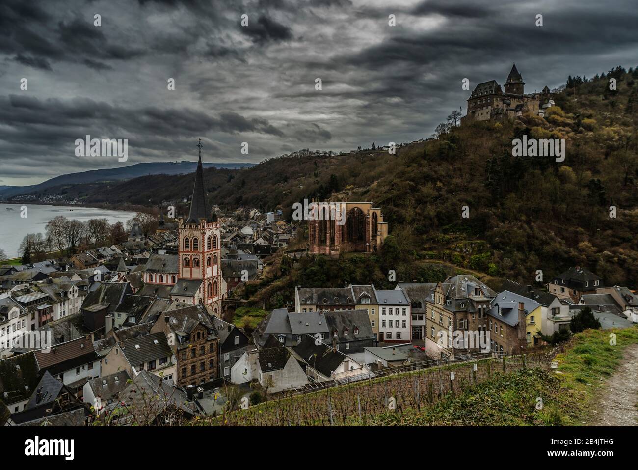 Bacharach on the Middle Rhine, dark and eerie, or romantic scary-beautiful version, evokes memories of gloomy medieval times, prominent church of St. Peter, the Werner Chapel and Castle Stahleck, part of the 'Unesco World Heritage Upper Middle Rhine Valley, Stock Photo