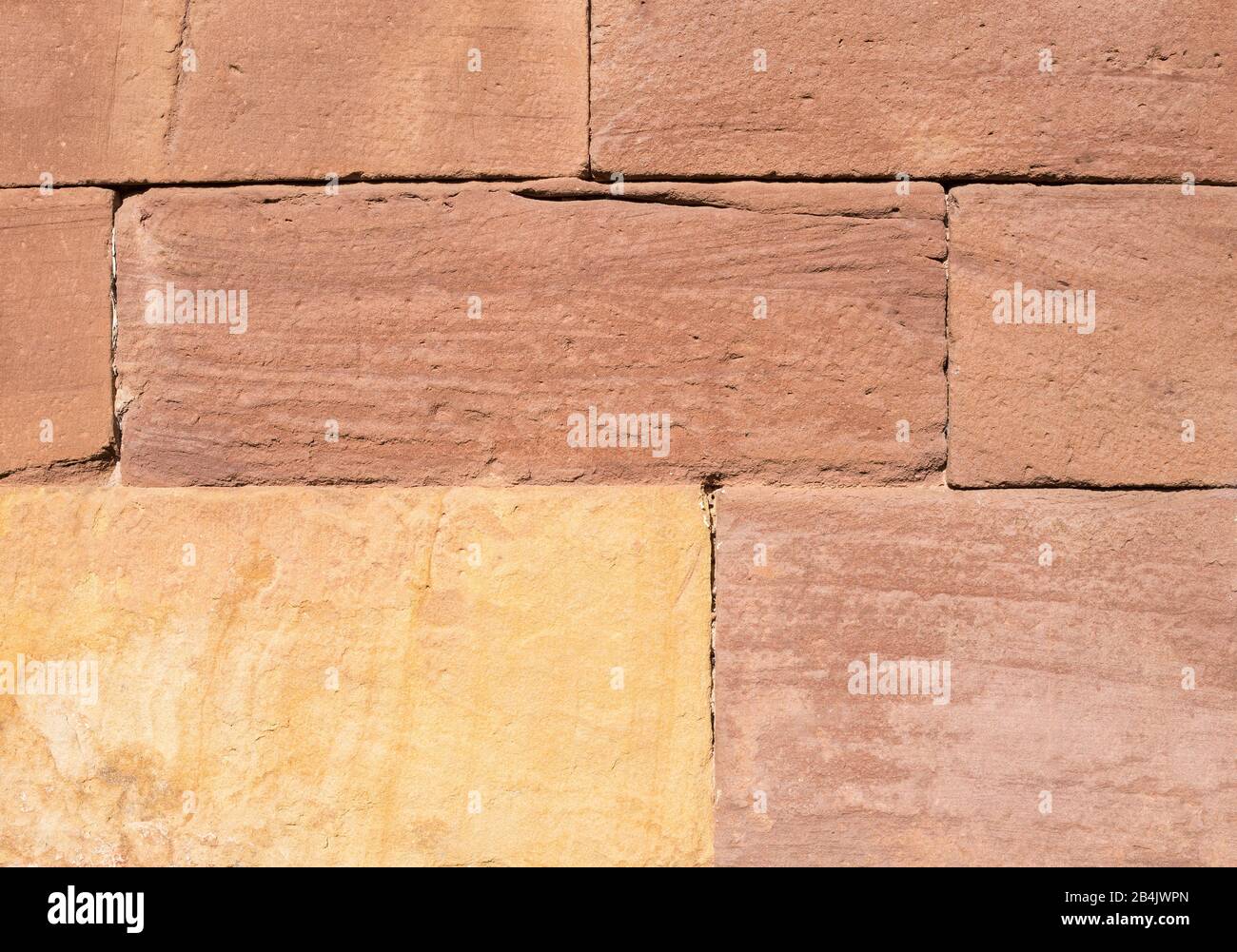 sandstone block wall in red and yellow shades for background Stock Photo