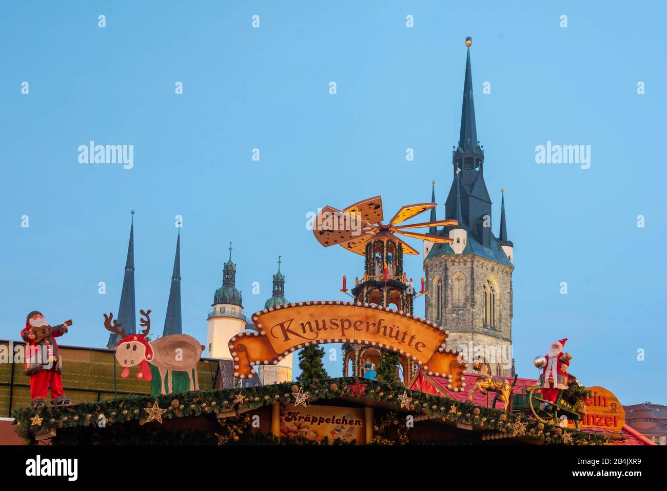 Germany, Saxony-Anhalt, Halle, looking at a stall at the Christmas market of Halle. In the background the market church Our Lady and the Red Tower. Stock Photo