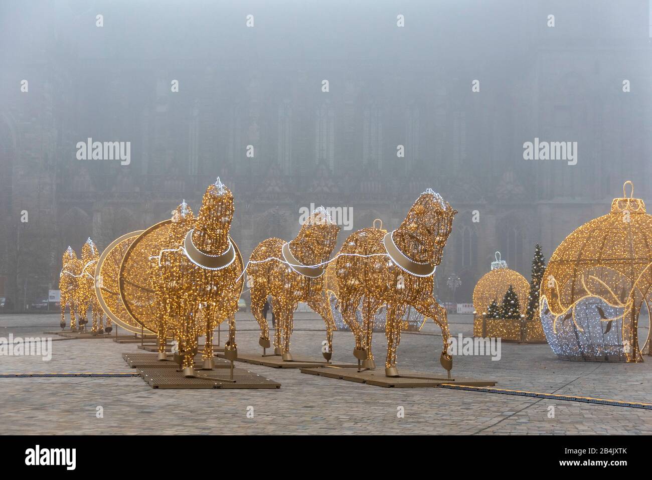 Germany, Saxony-Anhalt, Magdeburg, oversized Christmas balls and horses following the hemisphere attempt of the physicist Otto-von-Guericke stand on the cathedral square in Magdeburg. They belong to the world of lights in the city. In Advent, dozens of figures shine in Magdeburg, consisting of one million LED lights. They were made by the Polish company Multidekor. Stock Photo