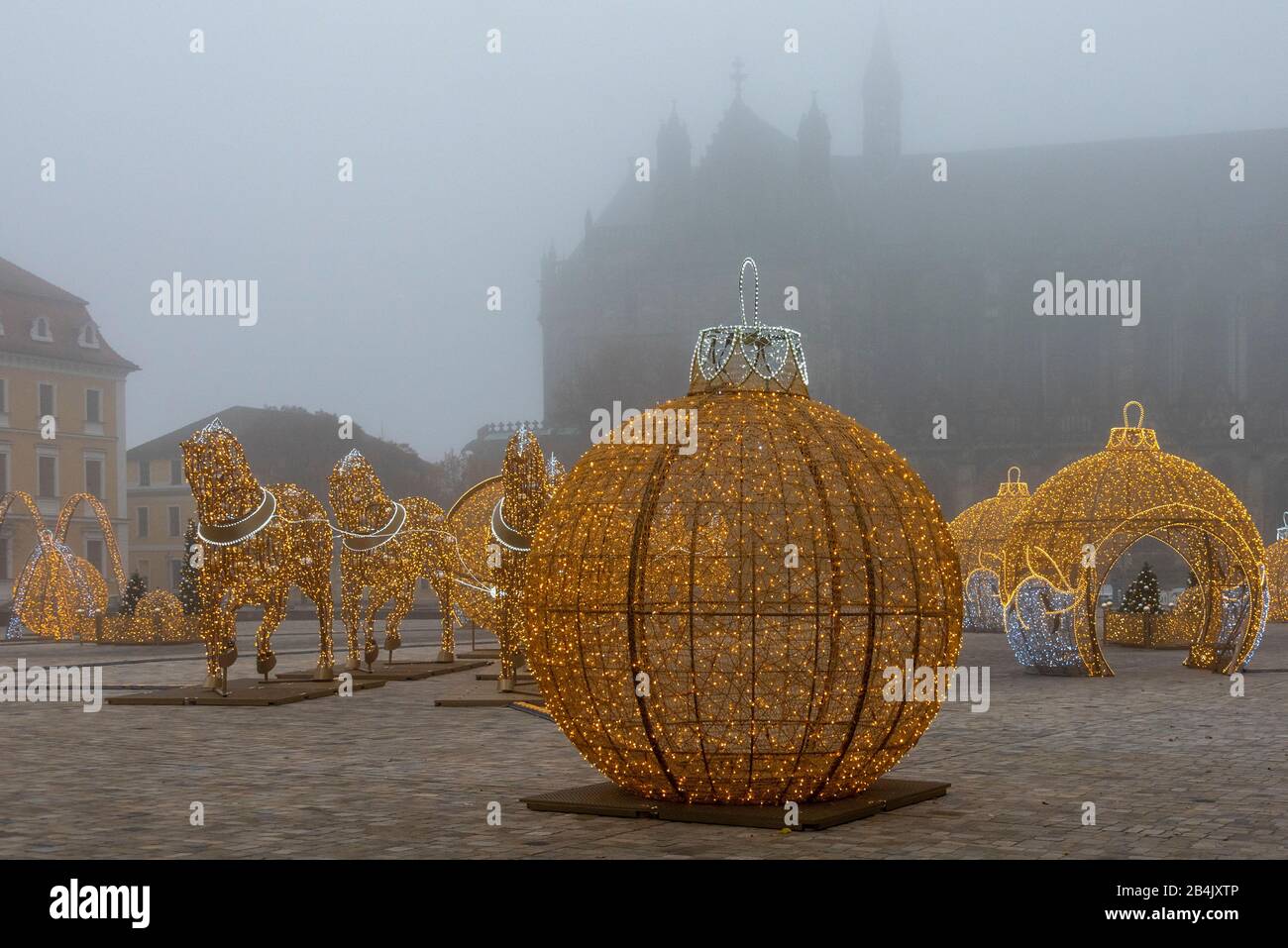 Germany, Saxony-Anhalt, Magdeburg, oversized Christmas balls and horses following the hemisphere attempt of the physicist Otto-von-Guericke stand on the cathedral square in Magdeburg. They belong to the world of lights in the city. In Advent, dozens of figures shine in Magdeburg, consisting of one million LED lights. They were made by the Polish company Multidekor. Stock Photo
