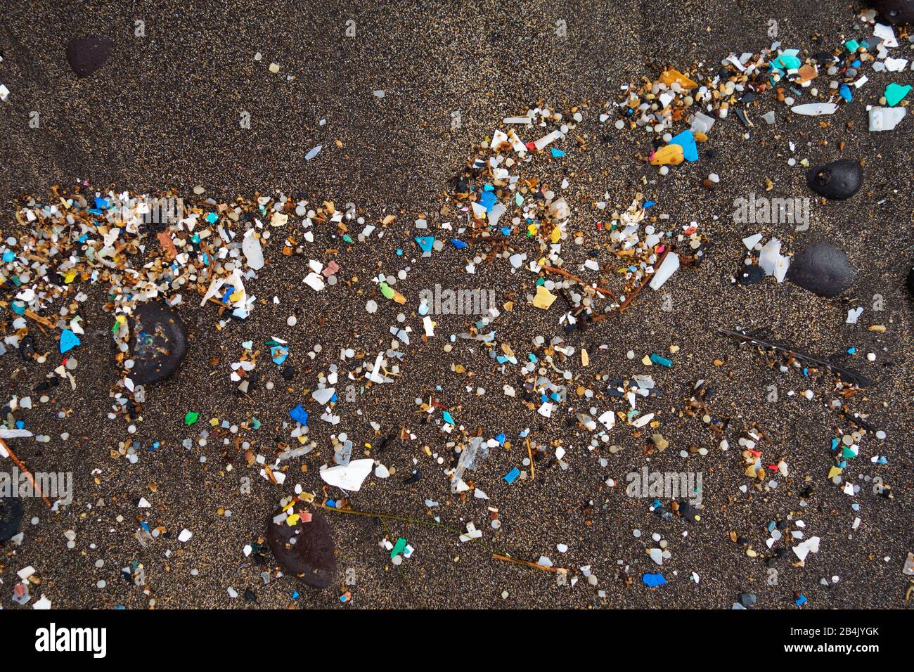 Microplastic washed up on dark lava sand, sandy beach, Playa Famara, Lanzarote, Canary Islands, Spain Stock Photo