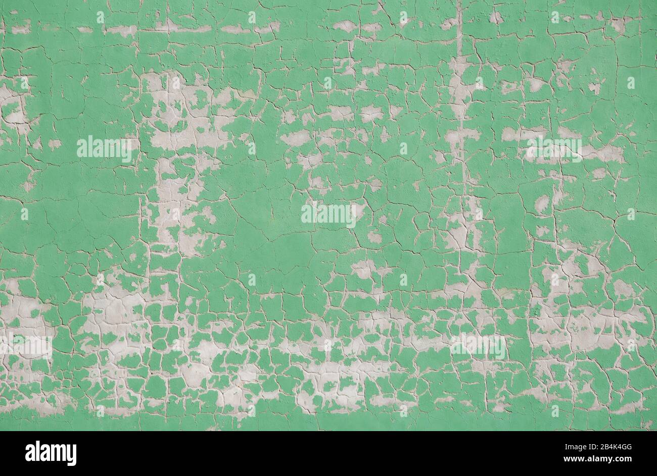 old light-colored green wall with chipped paint Stock Photo