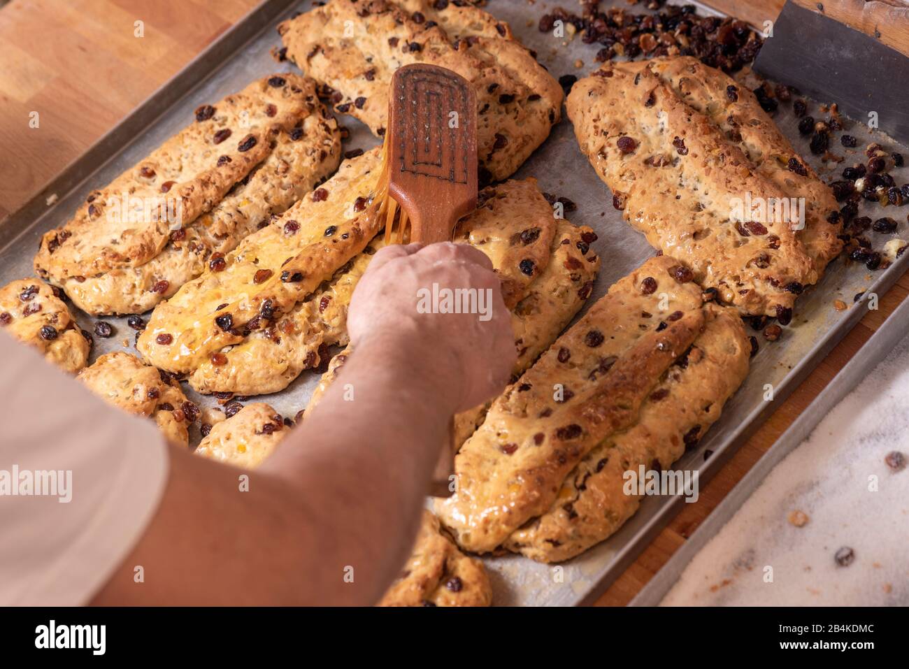 Baker sweets Christmas lunches with liquid butter. Stock Photo