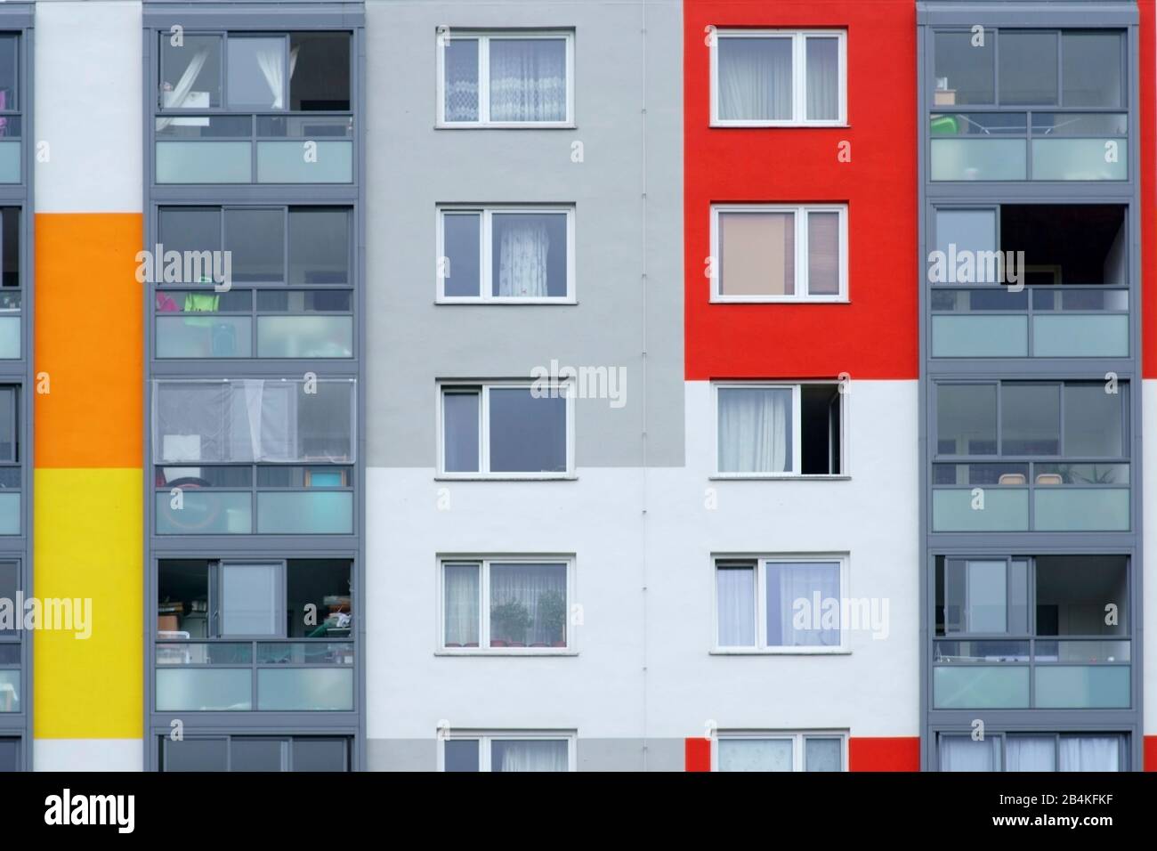 Household items are behind the windows of a multi-storey residential building. Stock Photo