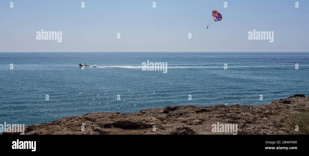 Parasailing by motorboat over sea Stock Photo