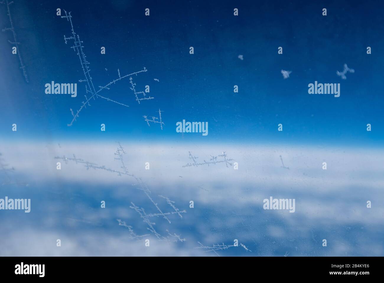 Eiskristalle am Flugzeugfenster vor blauem Himmel Stock Photo