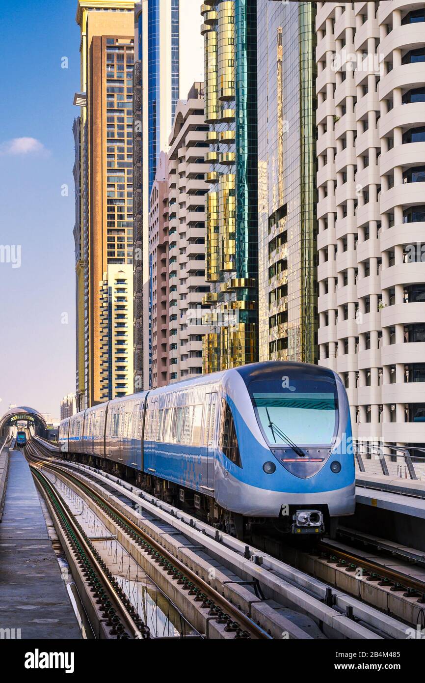 Metro train among skyscrapers of Sheikh Zayed Road in Dubai, UAE Stock Photo