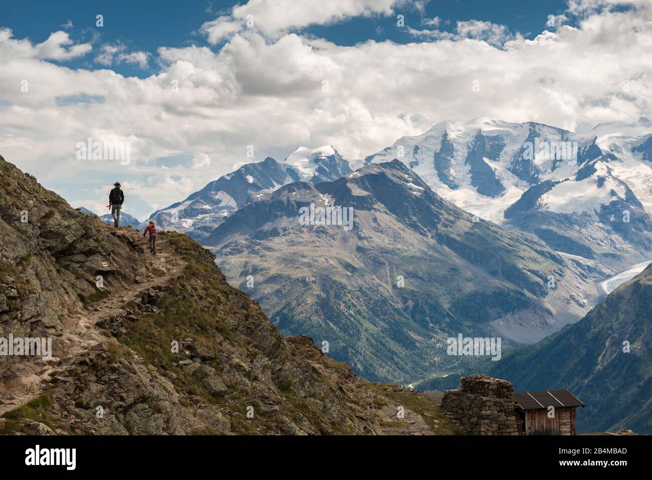 Schweiz, Graubünden, Engadin, Oberengadin, Bernina, Pontresina, Zwei Wanderer auf steinigem Weg mit Blick auf Piz Palü und Piz Cambrena Stock Photo