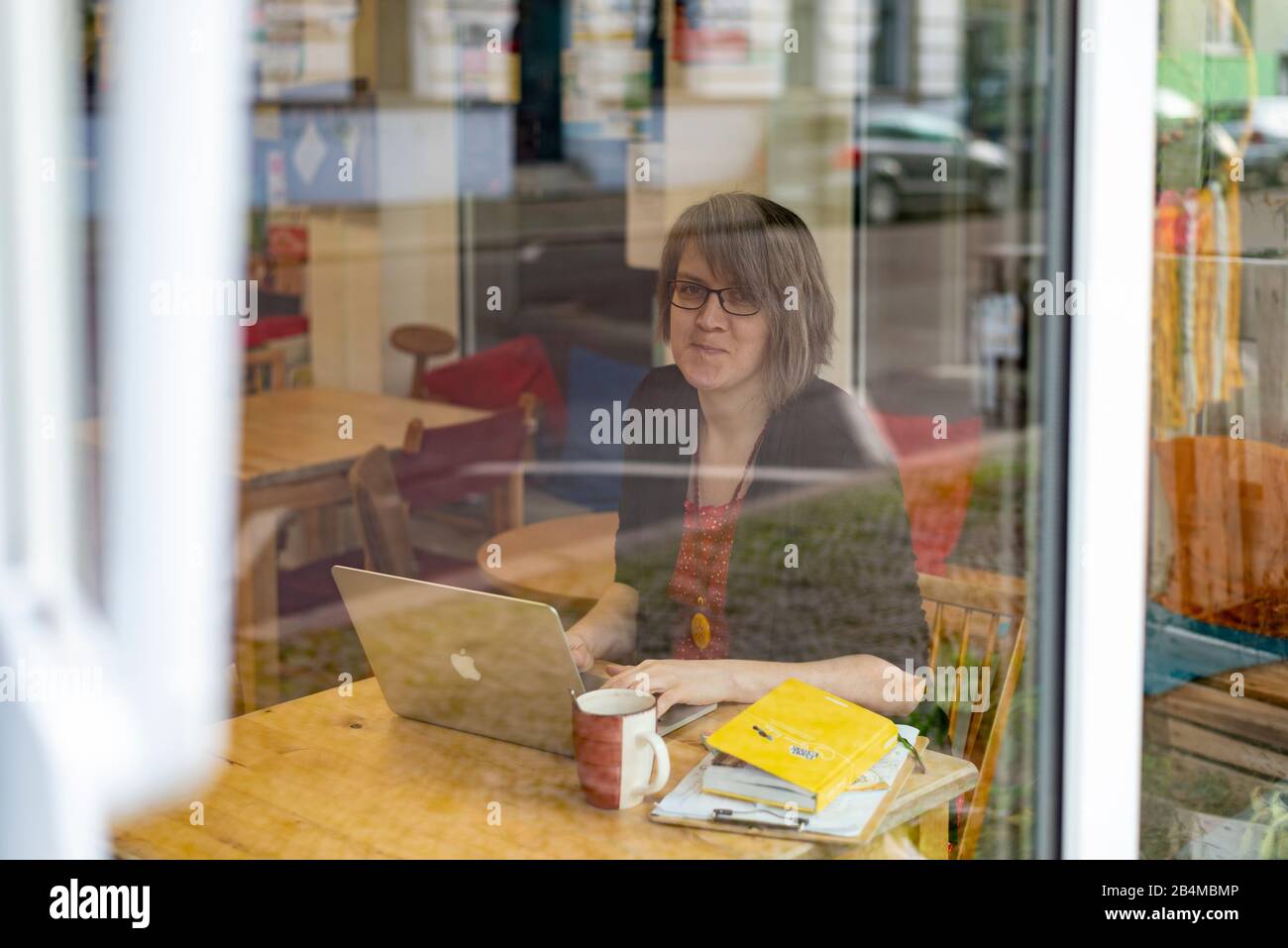 Junge Geschäftsfrau, sitzt vor einem Laptop, Inhaberin eines Unverpacktladens Stock Photo
