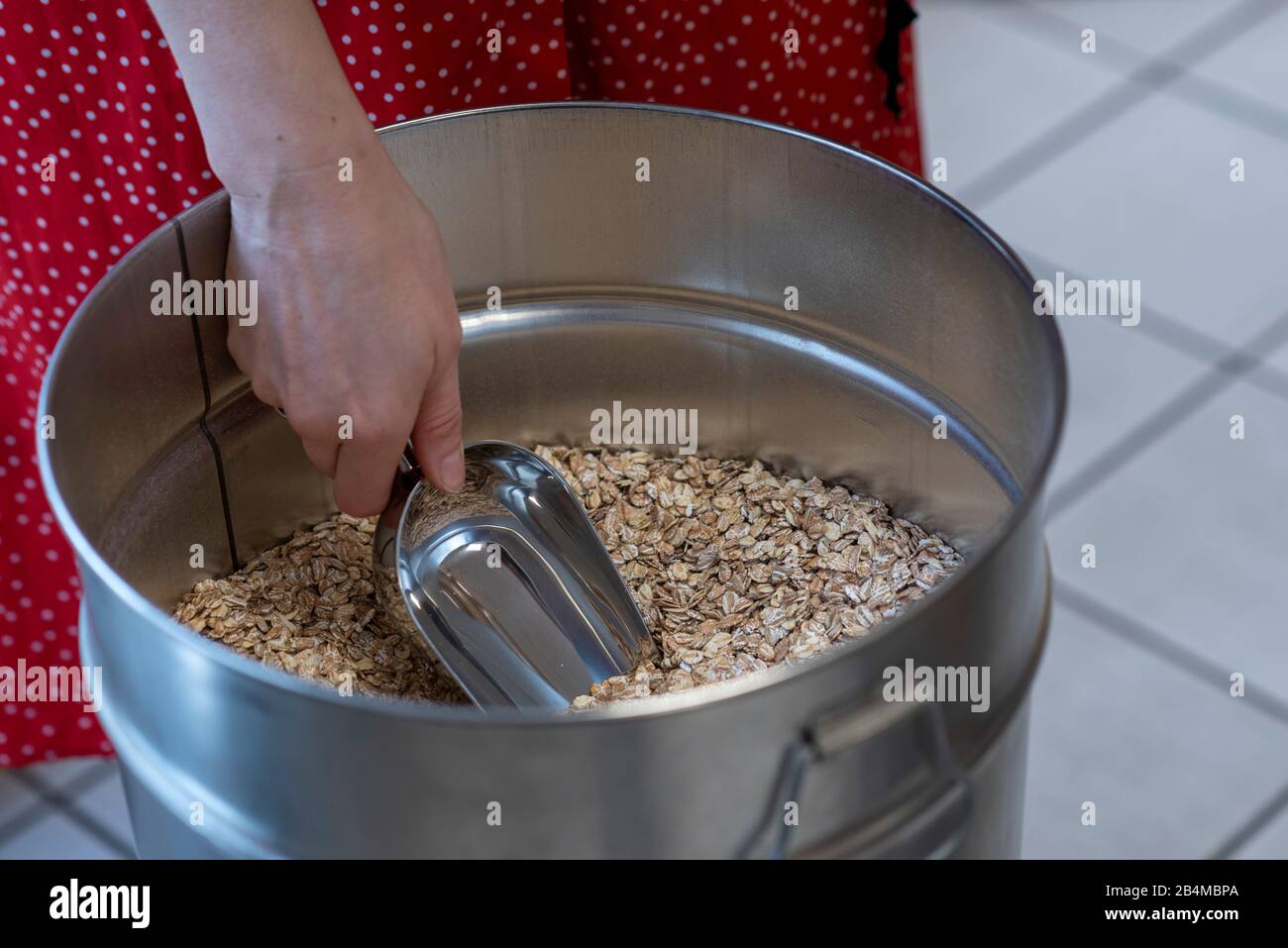 Eine Frau füllt Getreidekörner ab, Detail aus einem Unverpacktladen. Stock Photo