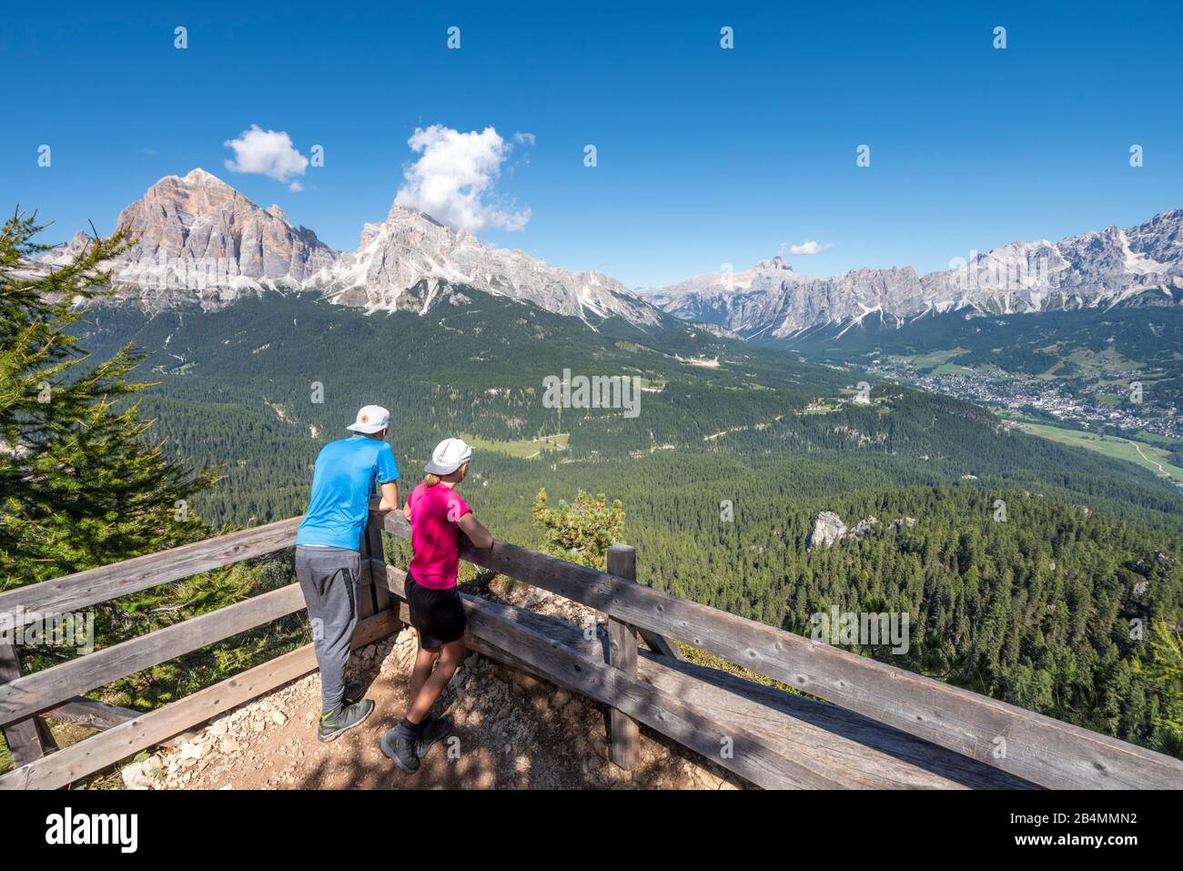Cortina d'Ampezzo, Provinz Belluno, Veneto, Italien, Europa. Kinder bewundern das Bergpanorama mit den Tofanegipfeln und der Stadt Cortina d'Ampezzo Stock Photo