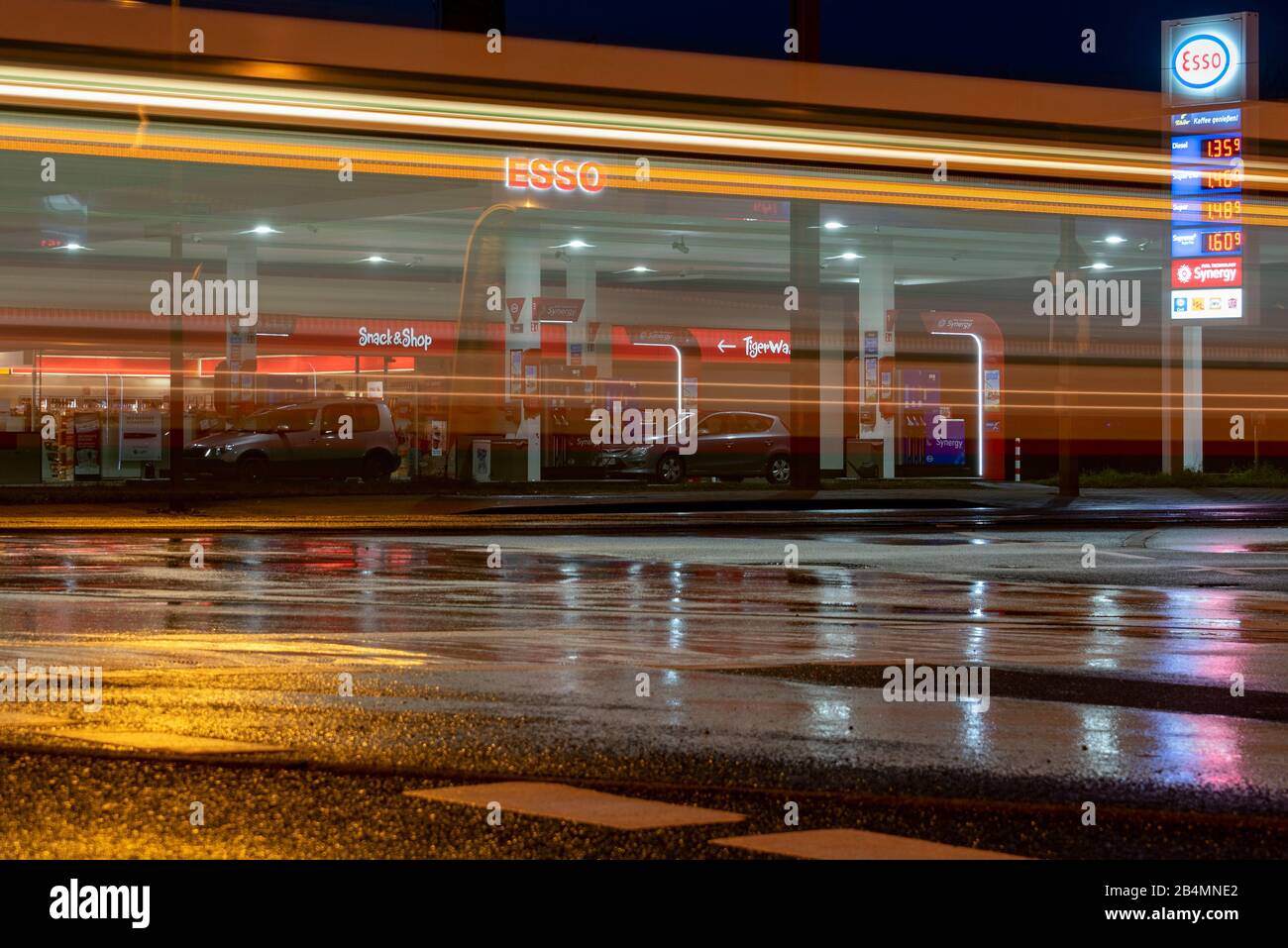 Deutschland, Sachsen-Anhalt, Magdeburg, Straßenbahn fährt an einer Esso-Tankstelle vorbei, nachts in Magdeburg. Stock Photo
