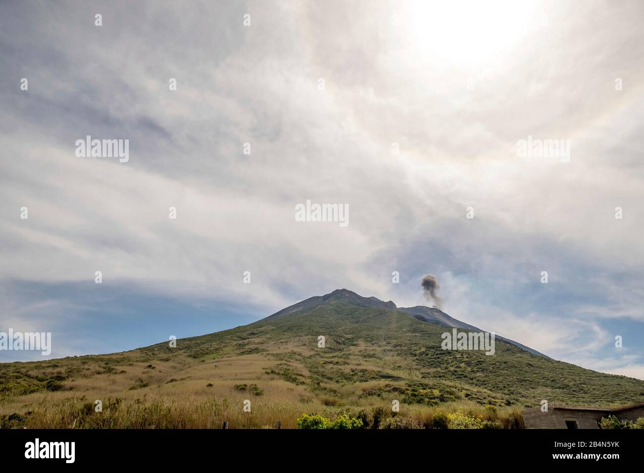 Stromboli volcano with cloud of smoke and green meadows, Lipari, Aeolian Islands, Aeolian Islands, Tyrrhenian Sea, Southern Italy, Europe, Sicily, Italy Stock Photo