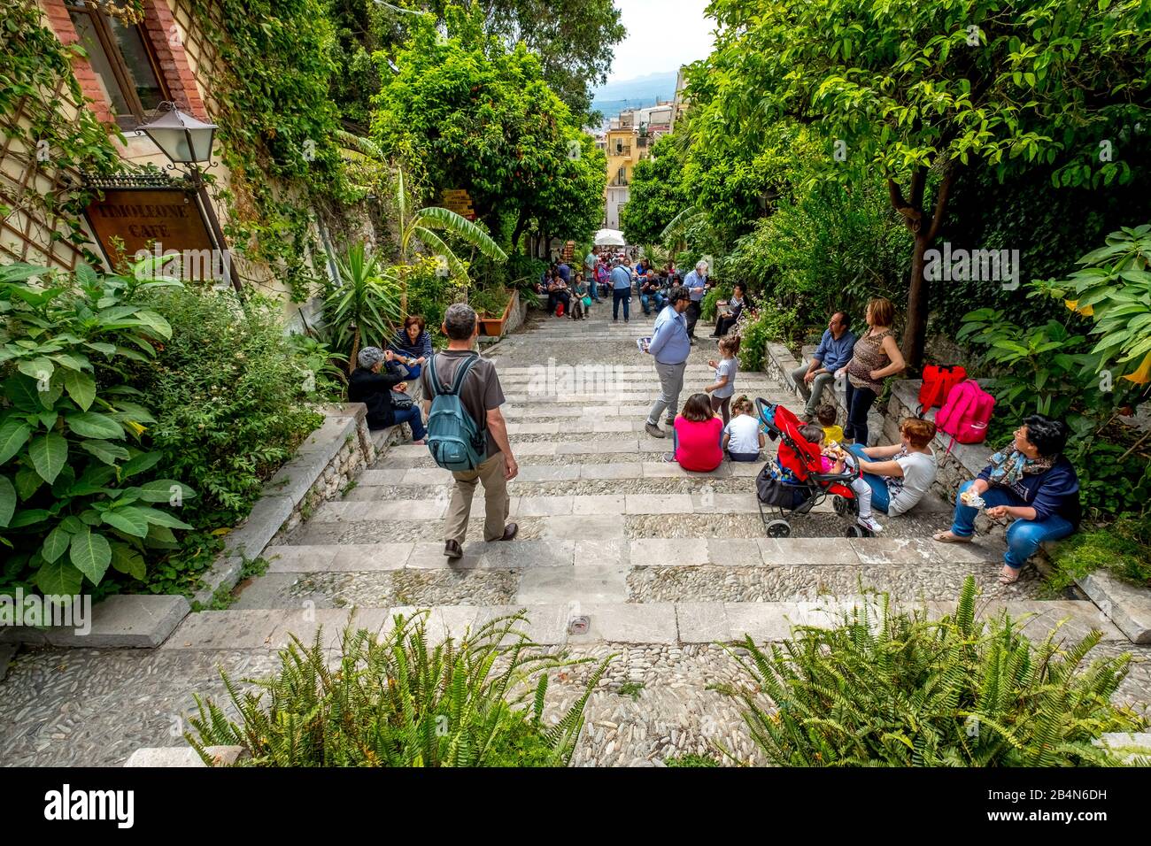 Tourists picnicking and taking a break on a staircase in Taormina, southern Italy, Europe, Sicily, Italy Stock Photo