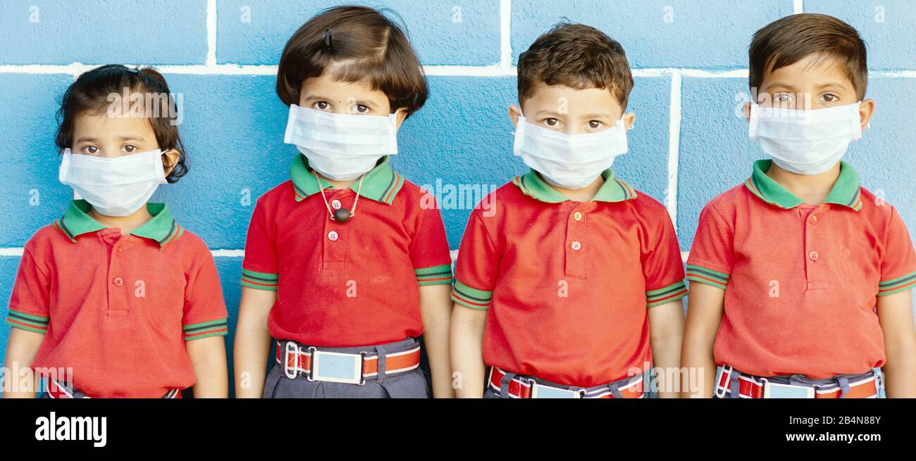 School preteen kids with protection face mask against new coronavirus, covid -19, nCov 2019 or sars cov 2 virus at school - children wore medical mask Stock Photo