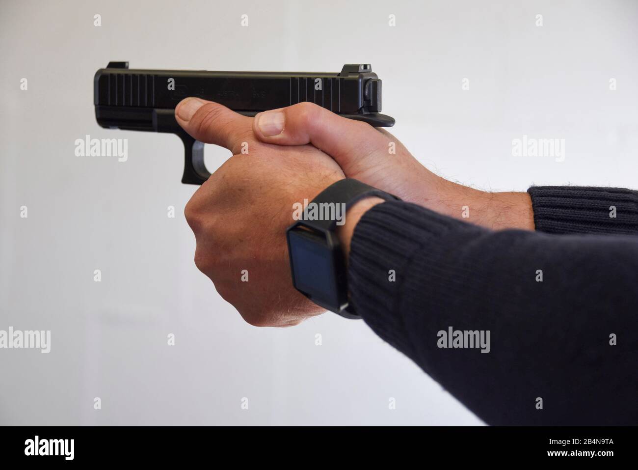 A police officer aims at a shooting range with a 'Glock 46' pistol. Stock Photo