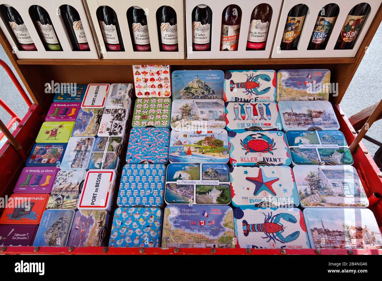 Cider or colorful tin cans with motifs for sale as souvenirs. Port-en-Bessin-Huppain is a commune in the Calvados department in the Normandy region in France. Stock Photo