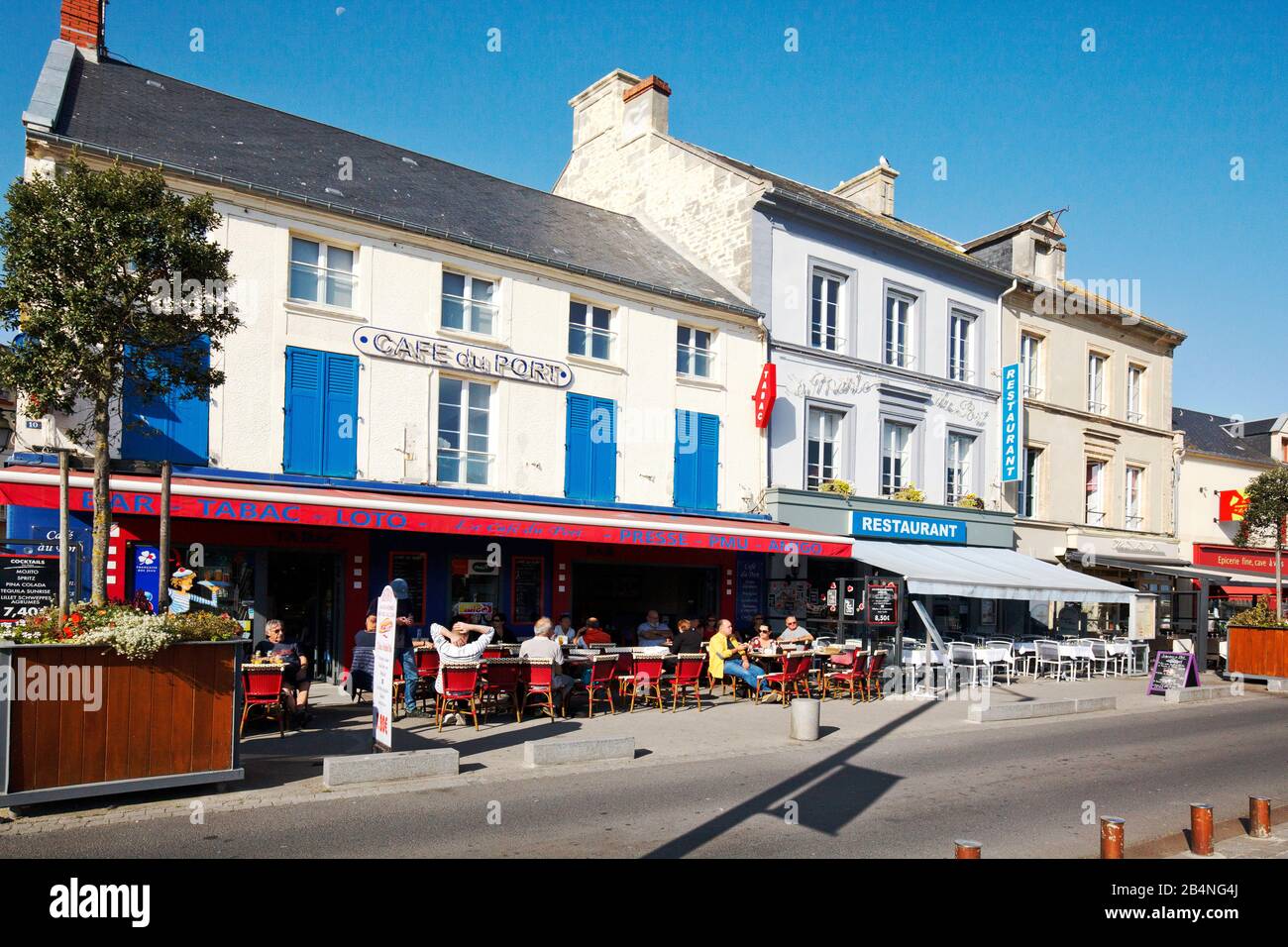 Cafe at the harbor with guests. Port-en-Bessin-Huppain is a commune in the Calvados department in the Normandy region in France. Stock Photo
