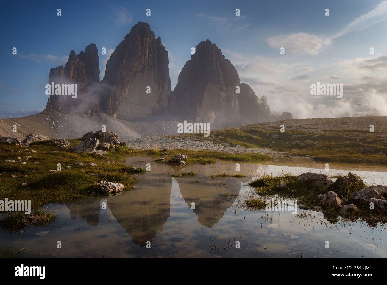 Drei Zinnen, Sesto Dolomites, South Tyrol, Italy, mountain range Drei Zinnen reflected in puddle after rain showers Stock Photo