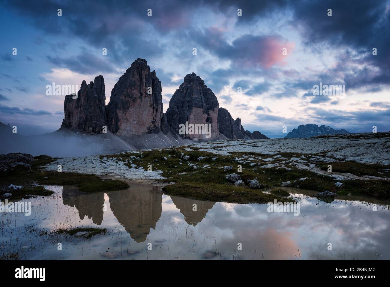 Drei Zinnen, Sesto Dolomites, South Tyrol, Italy, mountain range of the three peaks reflected in puddle after rain showers Stock Photo