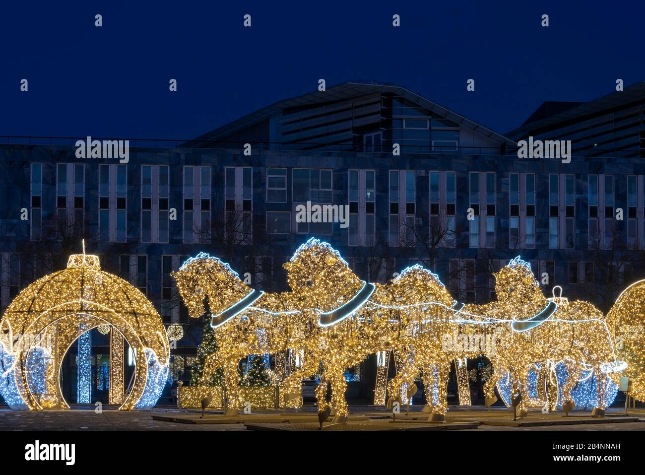 Deutschland, Sachsen-Anhalt, Magdeburg, auf dem Domplatz stehen beleuchtete Weihnachtskugeln und Pferde, die den berühmten Magdeburger Halbkugelversuc Stock Photo