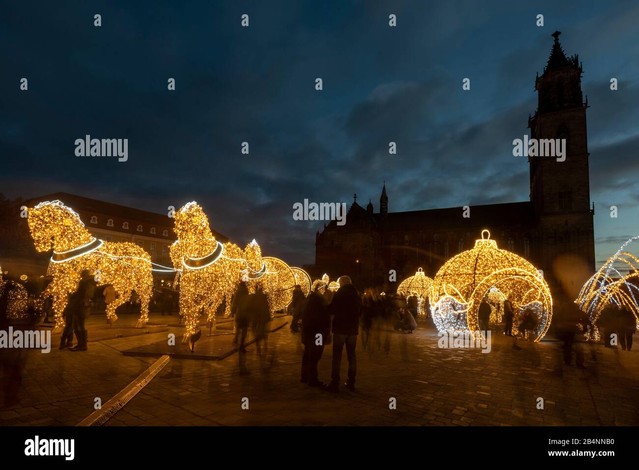 Deutschland, Sachsen-Anhalt, Magdeburg, dutzende Besucher gehen über den Domplatz zwischen weihnachtlichen Motiven hindurch, die Lichtskulpturen sind Stock Photo