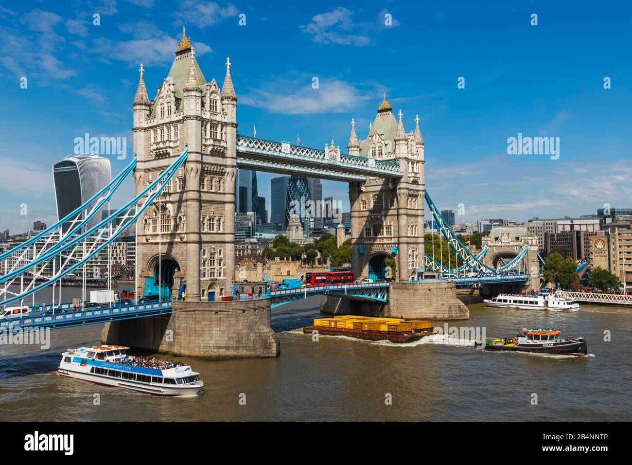 England, London, Tower Bridge and City of London Skyline with Various River Traffic Passing By Stock Photo