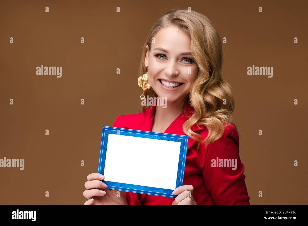 Smiling pretty lady with blank card posing in studio Stock Photo