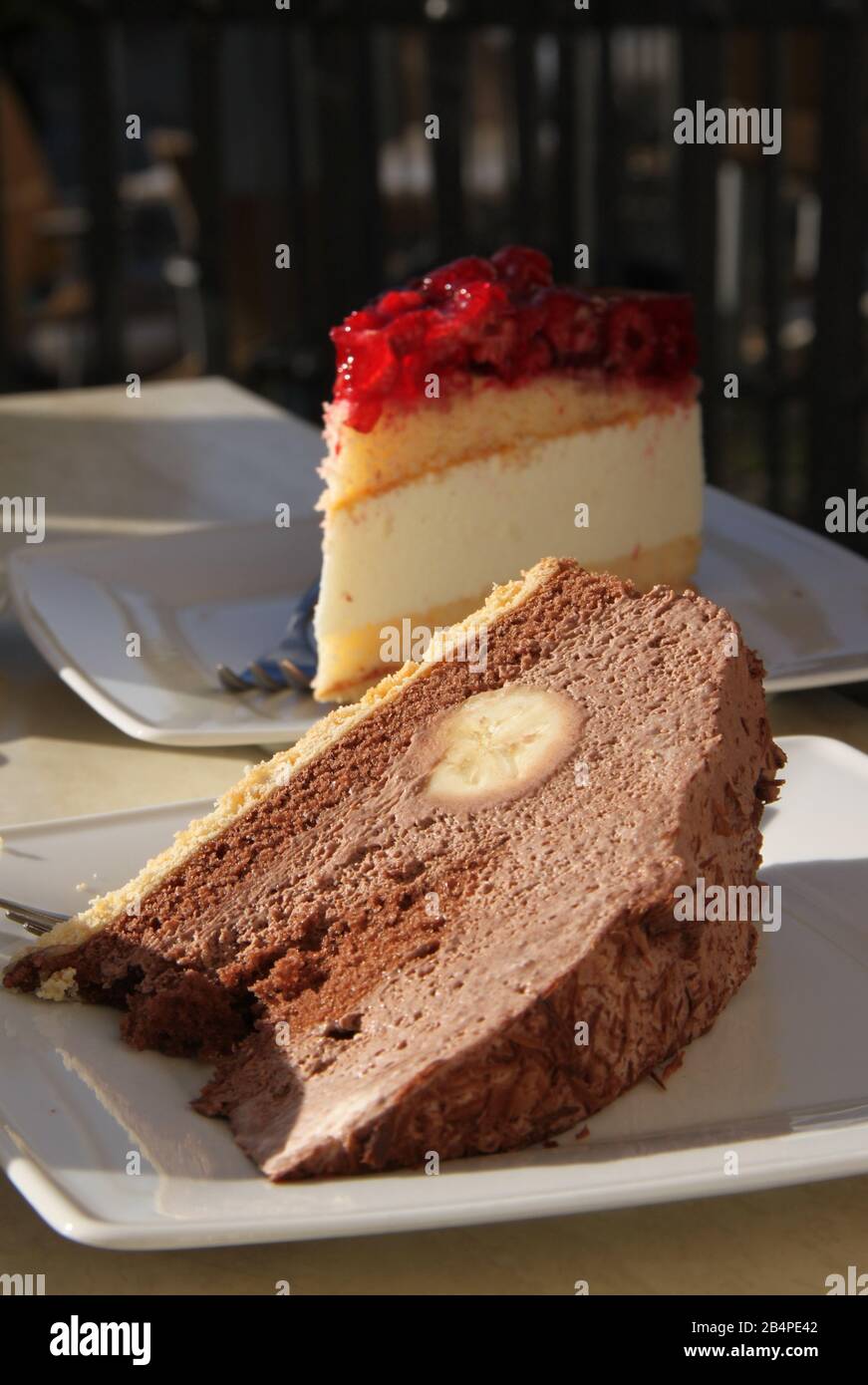 Chocolate banana cake and raspberry cake in background Stock Photo