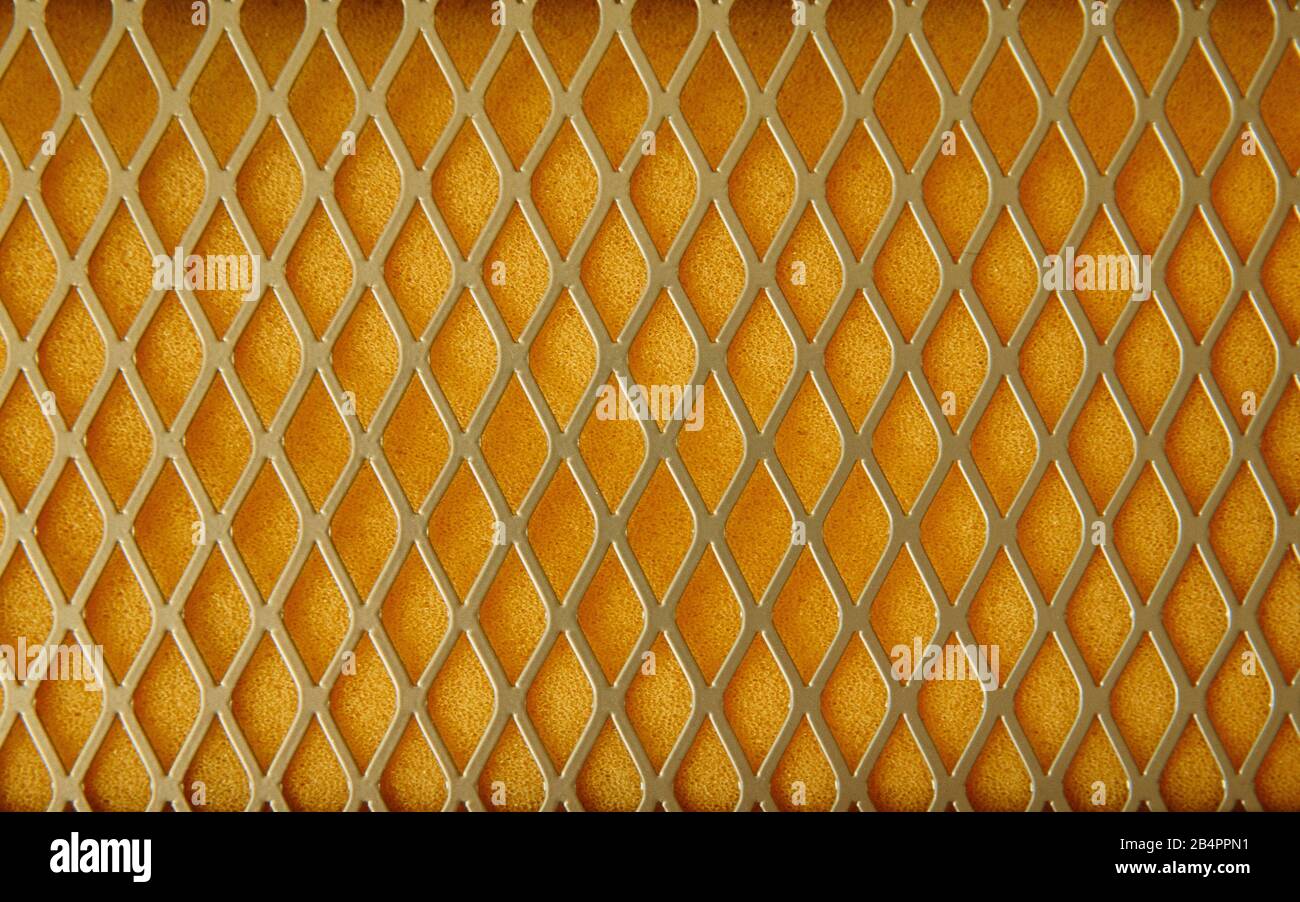 Texture of metal mesh and yellow foam lining. In foam rubber, pores are clearly visible. Stock Photo