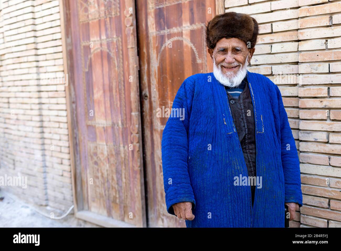 Uzbek man wearing a fur hat and traditional clothes, Uzbekistan, Bukhara Stock Photo