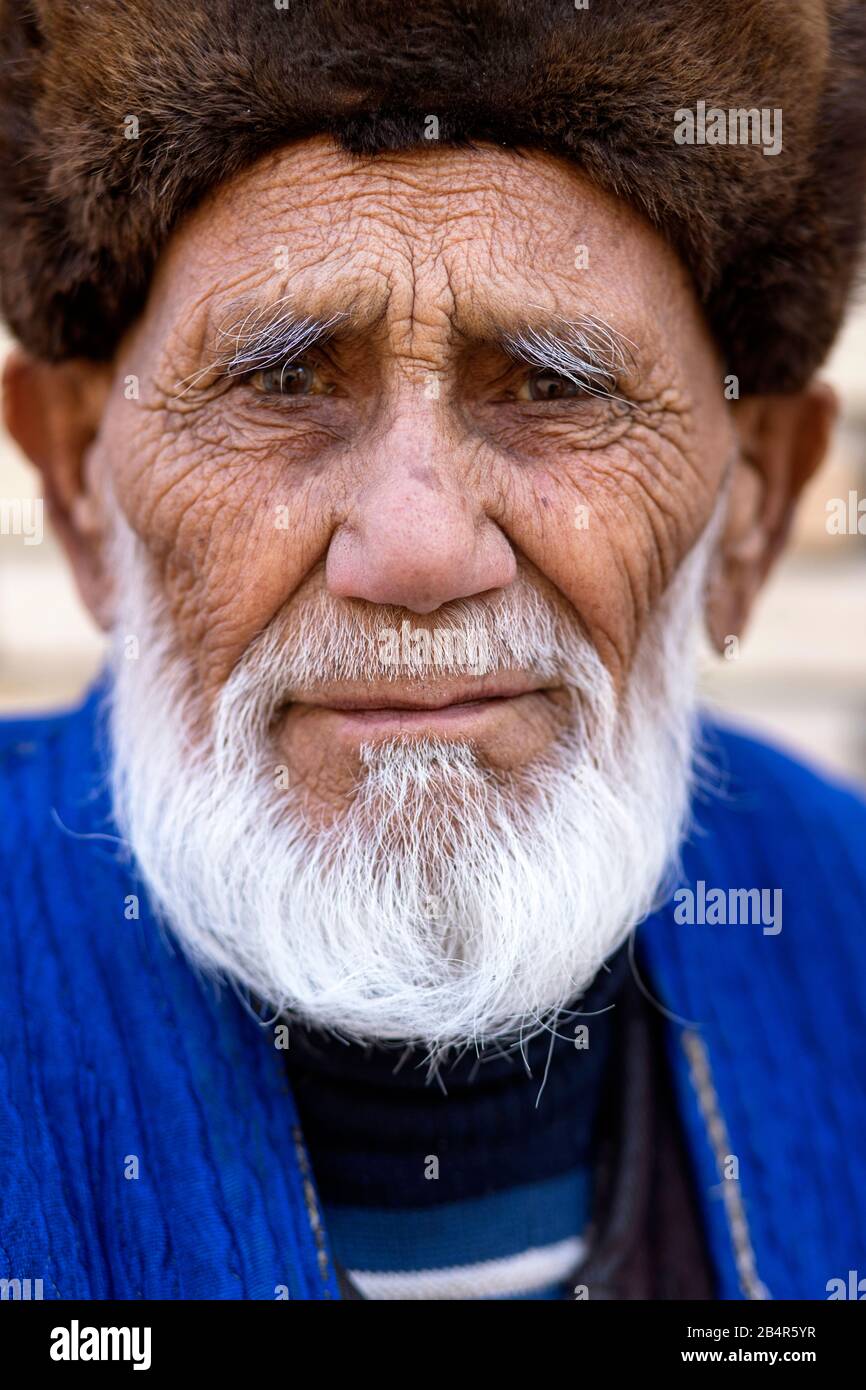 Uzbek man wearing a fur hat and traditional clothes, Uzbekistan, Bukhara Stock Photo