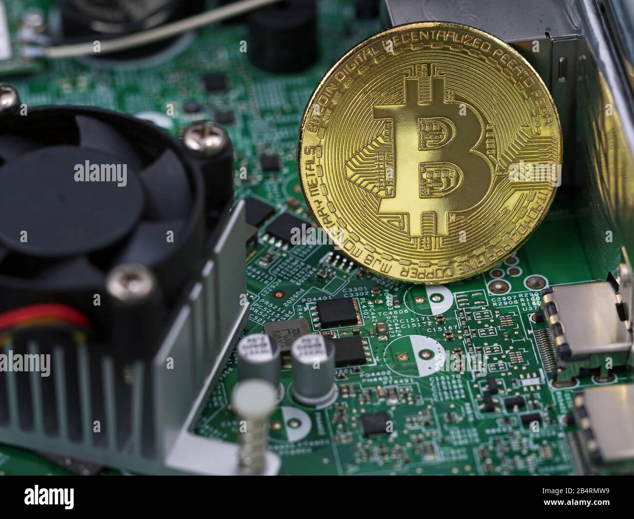 Bitcoin golden coin on computer motherboard between microchips and processor, concept of virtual cryptocurrency Stock Photo
