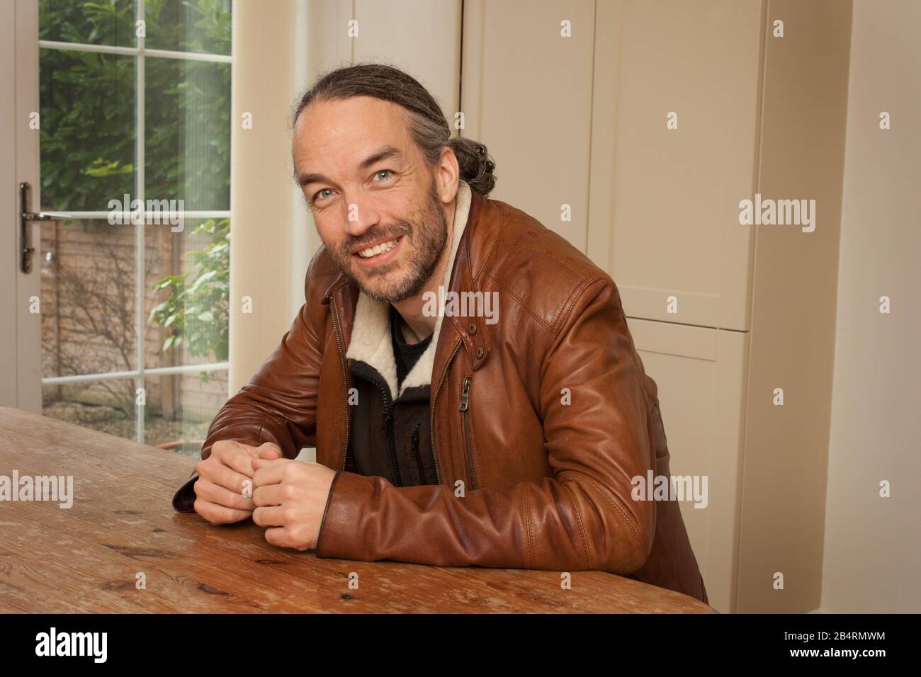 A portrait of a man sat at a table Stock Photo