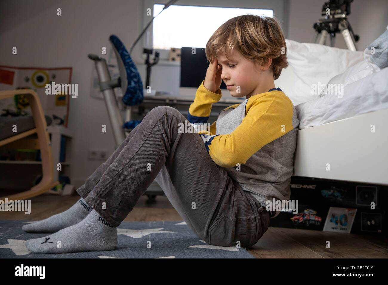 Child with headache, boy 9 years old, with pain distorted face