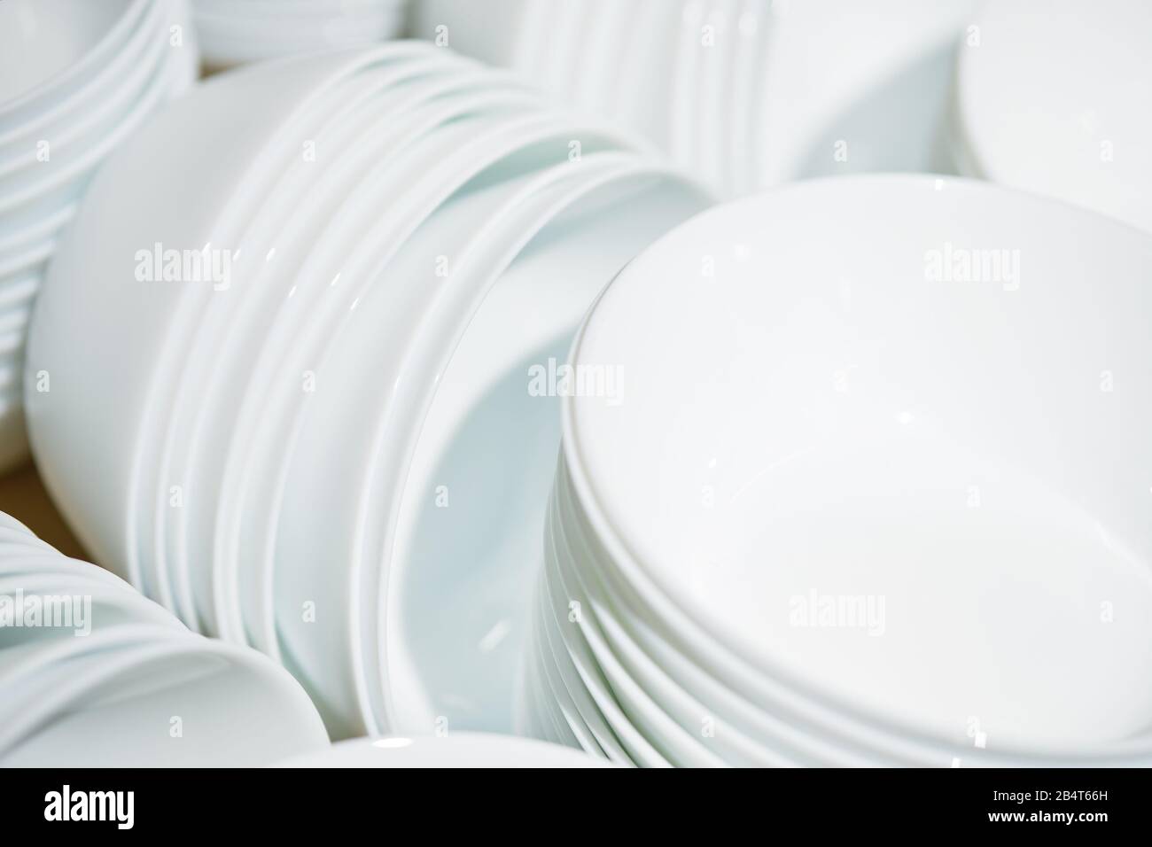 Modern folded white plates in piles. Close up. Stock Photo