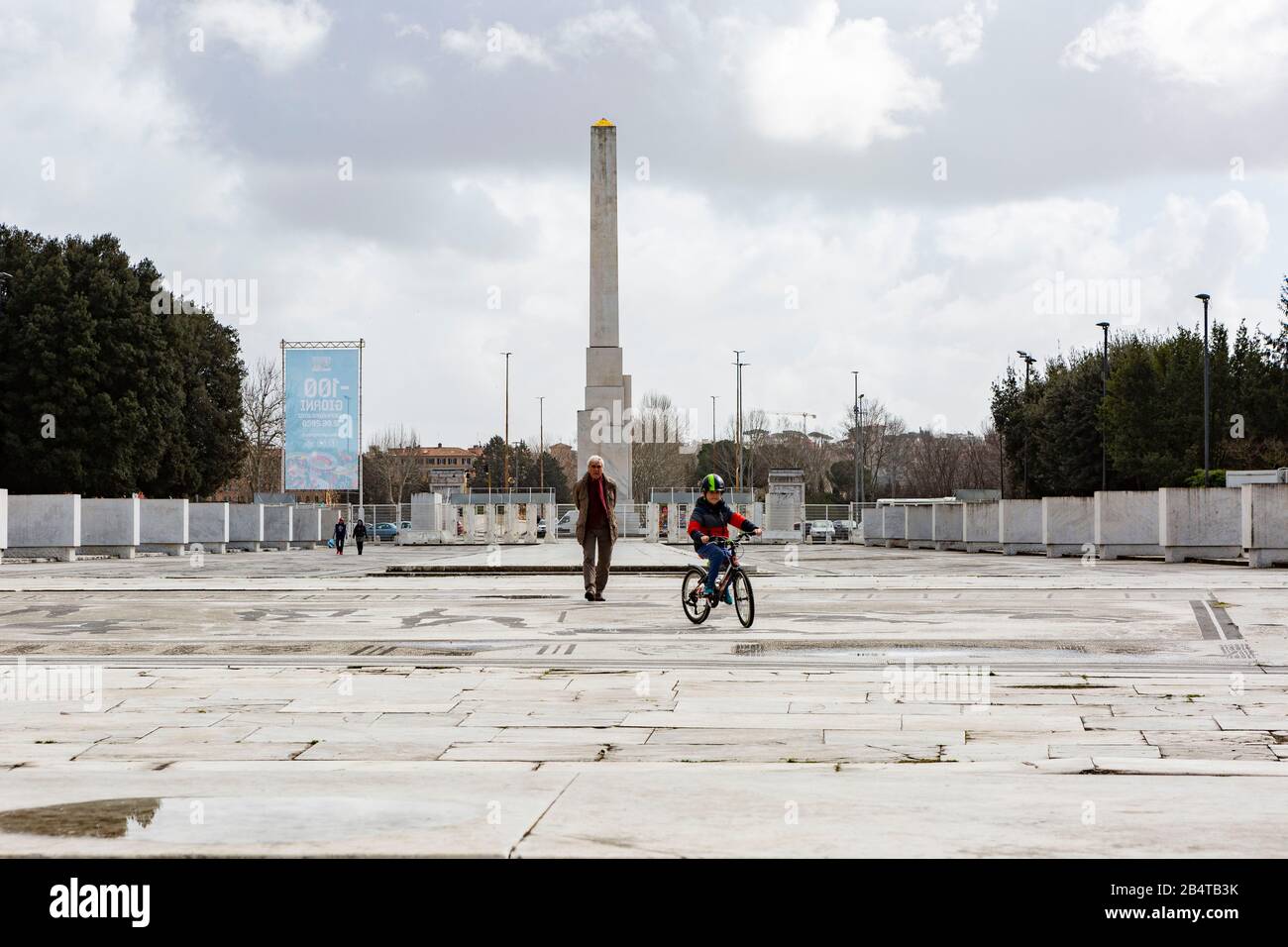 A grandfather accompanies his grandson to ride his bike on the Viale del Foro Italico near the Olympic Stadium in Rome. O Stock Photo