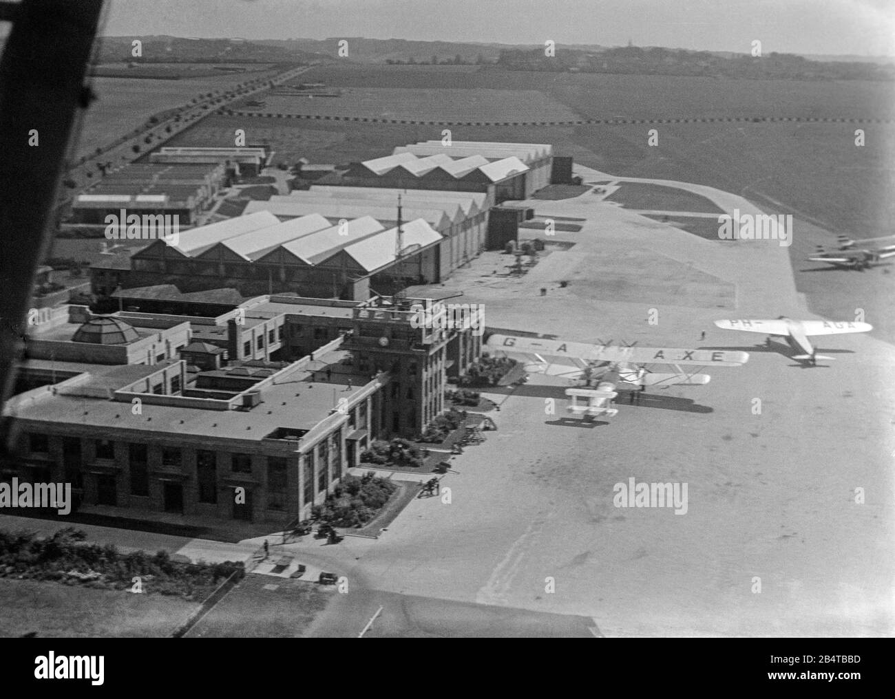 A vintage 1935 aerial photograph of Croydon Airport, aerodrome, near London, England. Photo shows an Imperial Airways Handley Page HP. 42, G-AAXE, and a Fokker F.IX, PH-AGA of KLM. Various Airport buildings and hangars can also be seen. Stock Photo